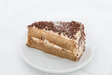 Chocolate cake slice with curl on white dish