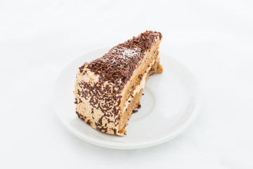 Chocolate cake slice with curl on white dish