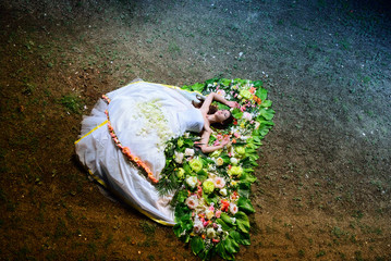bride lying on the flowers in a wedding dress