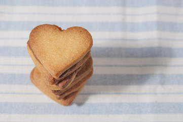 Butter cookies, heart shaped, on a striped fabric napkin