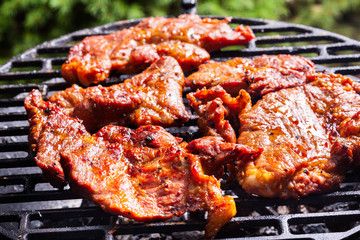 Grilling pork steaks on barbecue grill