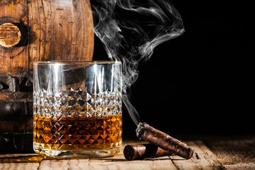 Glass of alcohol and smoking noble cigar on a black background - 75239744
