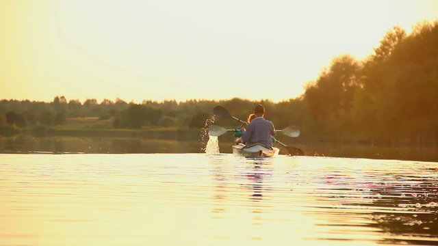 Active couple kayaking at sunset. Healthy way of living, sport