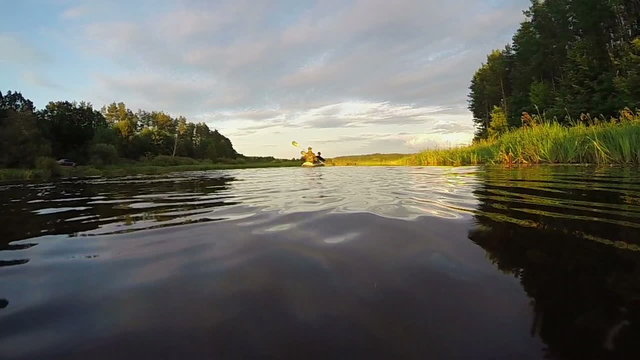 Kayaking at high speed. Majestic river landscape, sunset