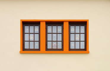 Dunkle Holzfenster mit orangeroter Fenstereinfassung