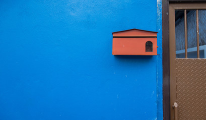 Red mail box on the blue concrete wall