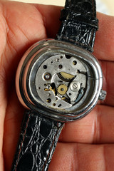 Uhrmacher mit alter geöffneter Armbanduhr