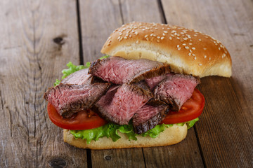 roast beef hamburger sandwich on a wooden surface
