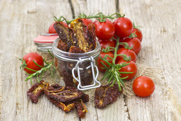 fresh and dried tomatoes on wooden background