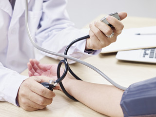 doctor measuring blood pressure of a patient