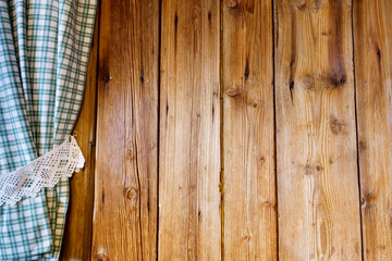 Holzwand mit blau weiß kariertem Vorhang