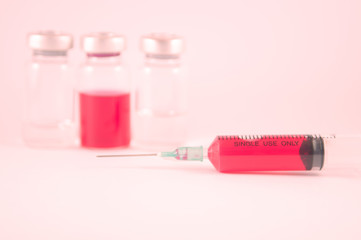 Red liquid in injection syringe and vials