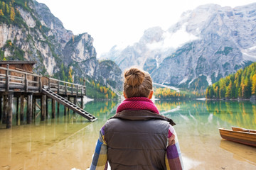 Young woman on lake braies in south tyrol, italy. rear view