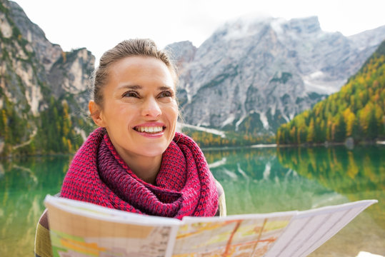 Portrait of happy woman with map on lake braies in south tyrol