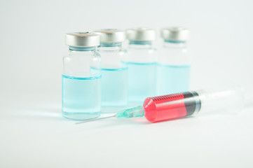 Red liquid in injection syringe and vials