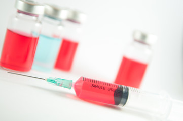 Red liquid in injection syringe and vials