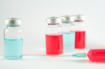 Red liquid in injection syringe and vials