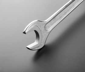 Stainless steel spanner on dark