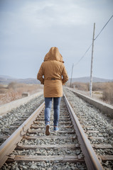 Young woman walking on a railway. Rural setting - 75278384