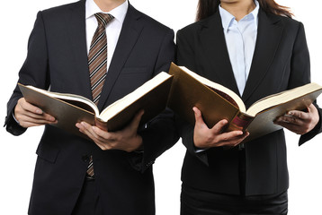 難しい本を読んで調べている男女の二人のビジネスマン