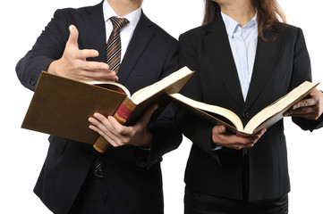 難しい本を読んで調べている男女の二人のビジネスマン