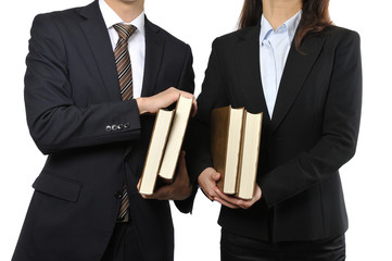 難しい本を読んで調べている男女の二人のビジネスマン