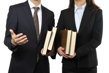 難しい本を読んで調べている男女の二人のビジネスマン