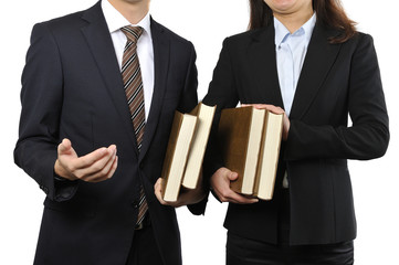 難しい本を読んで調べている男女の二人のビジネスマン