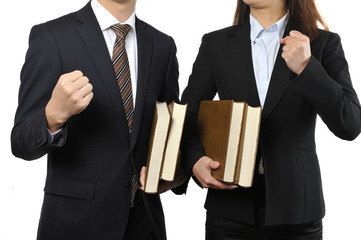 難しい本を読んで調べている男女の二人のビジネスマン