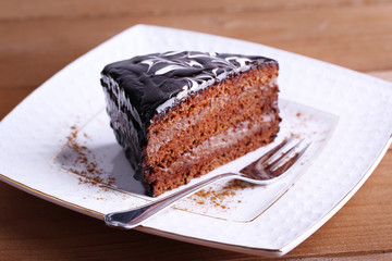 Delicious chocolate cake on plate on table close-up