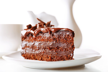 Delicious chocolate cake on plate on table on light background