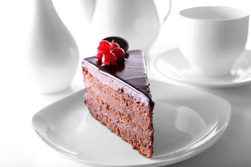 Delicious chocolate cake on plate on table on light background