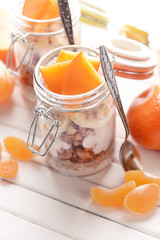 Healthy layered dessert with muesli and fruits on table