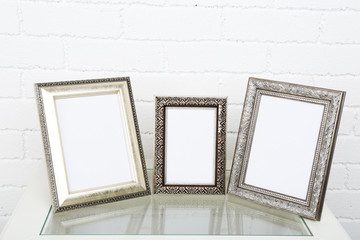 Photo frames on coffee table on brick wall background
