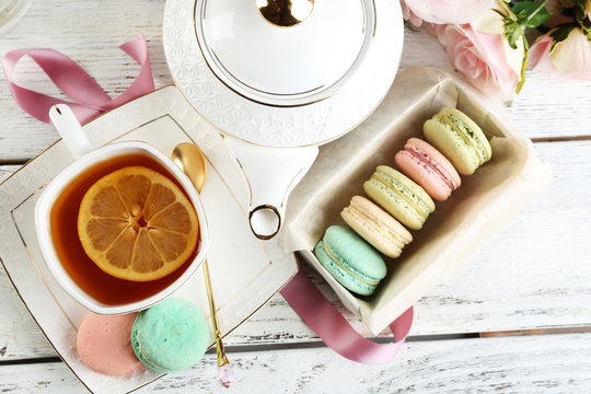 Colorful macaroons with cup of tea