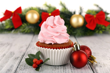 Cup-cake with Christmas decoration on wooden surface background