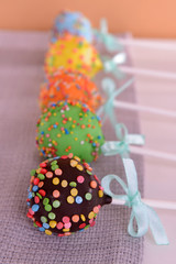 Sweet cake pops on table on beige background