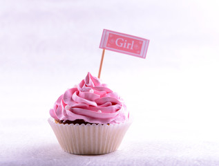 Delicious cupcake with inscription on table on beige background