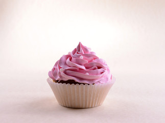 Delicious cupcake with inscription on table on beige background