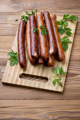 Wooden chopping board with sausages, studio shot