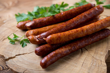 Smoked sausages over wooden background, close-up