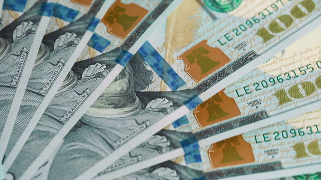 Spinning pile of 100 dollar bills close up
