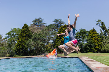 Fototapeta na wymiar Girls Jumping Pool