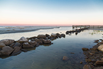 Rock Seawall in Calm Bay at Sunset