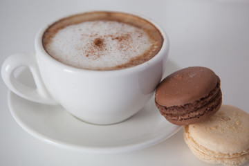 Cup of cappuccino with macaroon cookies