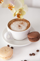 Cup of cappuccino with macaroon cookies
