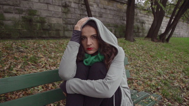 Sad woman in hoodie looking to camera, steadycam, slow motion 