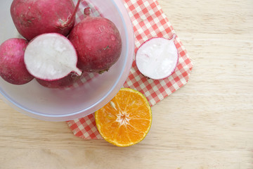 Radish in bowl on wooden table