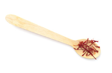 Saffron spice on small spoon, isolated on white background