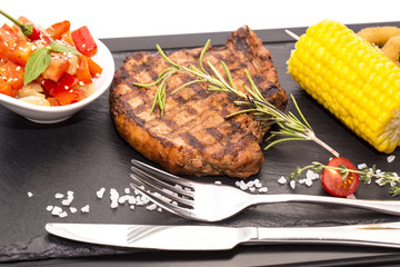 Grilled steak with sauce and greens